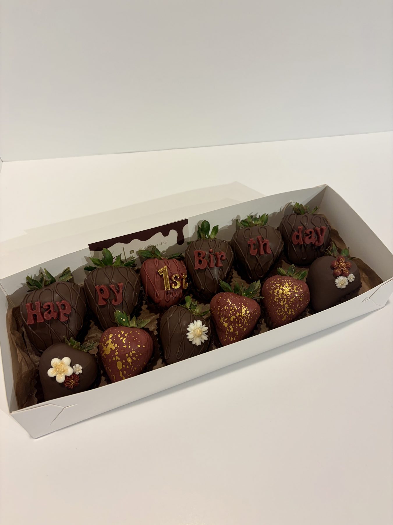 Chocolate-dipped strawberries spelling Happy 1st Birthday