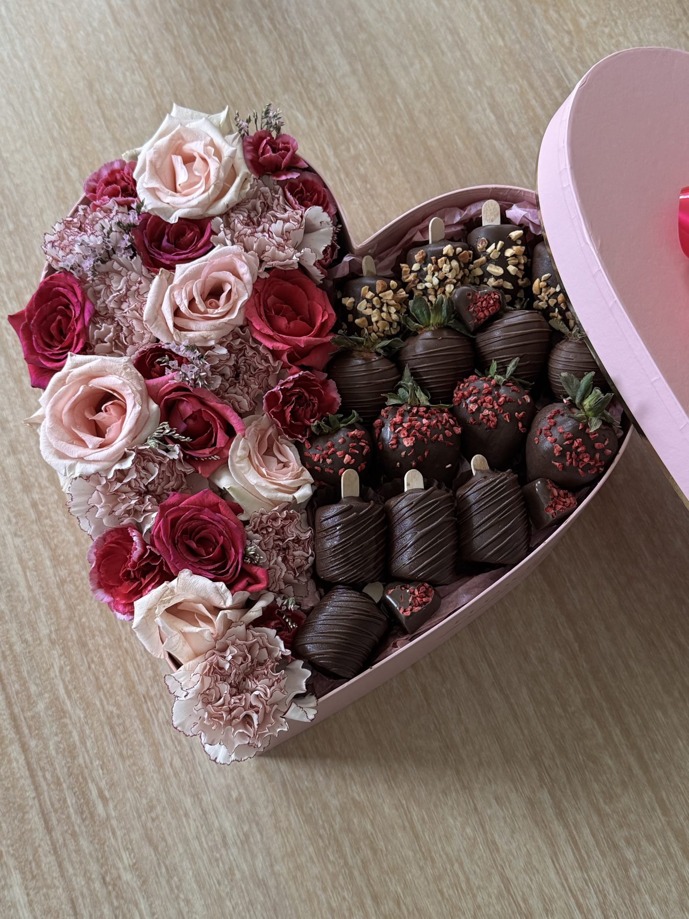 Heart-shaped gift box with roses and dipped strawberries